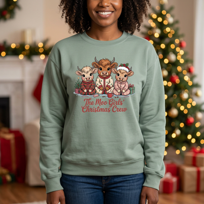 Woman modeling The Moo Girls’ Christmas Crew sweatshirt in Sage in a festive Christmas living room