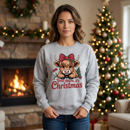 Female model wearing Ash Grey Bow Down It's Christmas sweatshirt in a festive fireplace setting