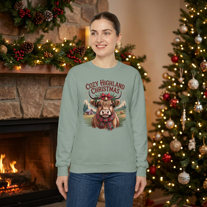 Female model wearing Sage Cozy Highland Christmas sweatshirt in a festive fireplace setting