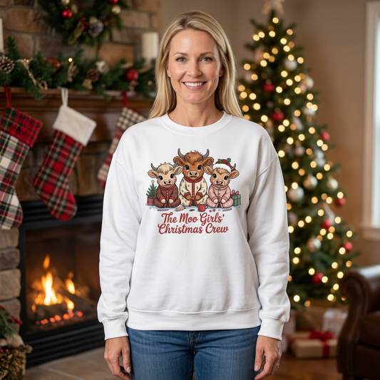 Woman modeling The Moo Girls’ Christmas Crew sweatshirt in White beside a Christmas fireplace